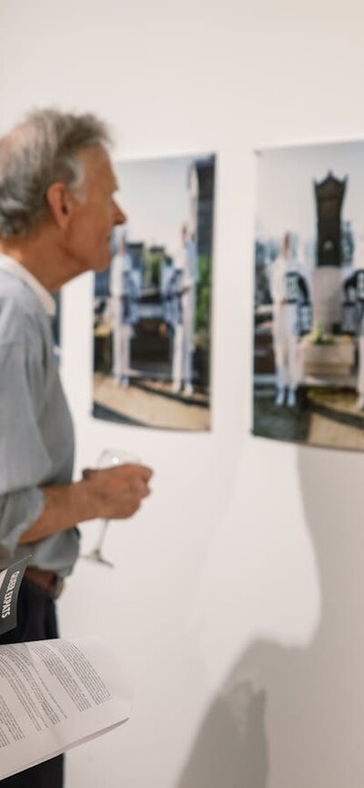 Two men look at photographs on the gallery wall