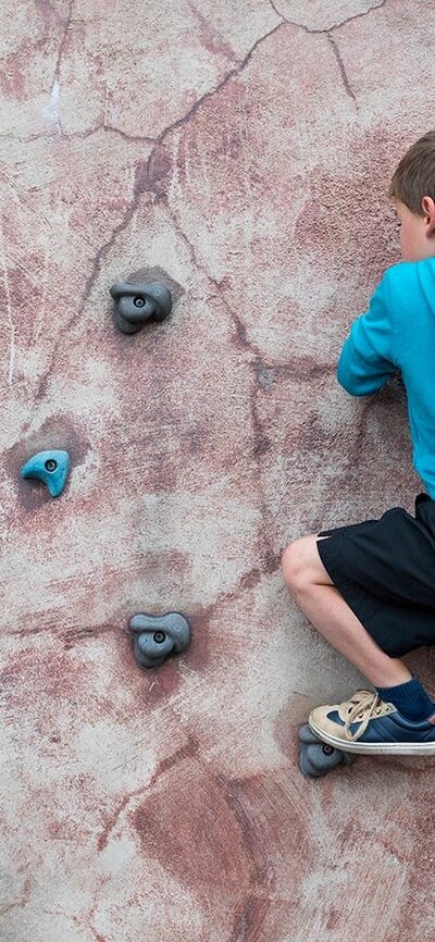 Boy climbing on bouldering wall