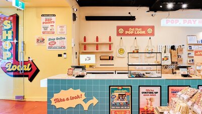 A bright and inviting interior of POP Canberra, featuring a checkout counter, merchandise.