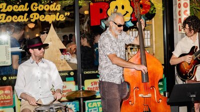 A jazz trio performing outside POP Canberra, entertaining shoppers at community events.