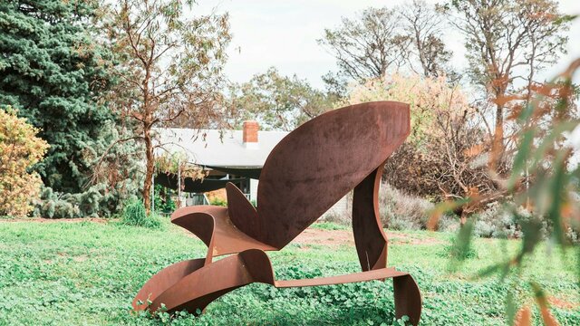 Strathnairn's gardens are full of sculptures. An abstract steel sculpture of geometric forms with a rusty patina in the garden.