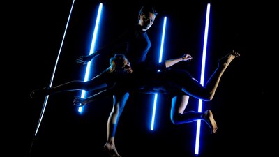 Dancers in the dark with neon bulbs