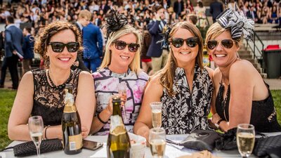 Ladies dressed for the races enjoying champagne