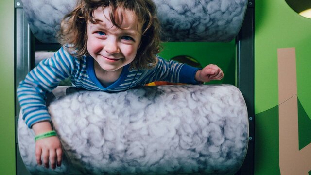 Photo of a child climbing through the sheeps pen