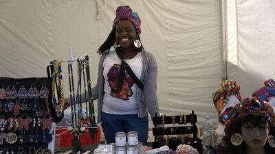 lady smiling at market stall at African Festival in the Park