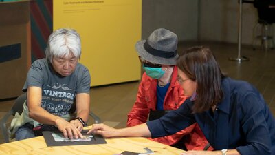 Art by Description Tour with Activity A photograph of 2 participants of Art by Description and a staff member using tactile resources