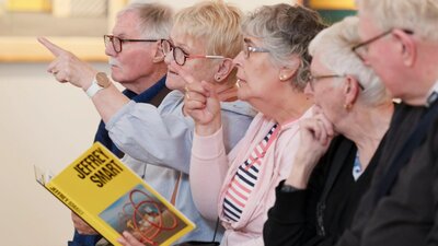 A group of people participating in an Art with Auslan tour A photograph of 5 people in a gallery space pointing and looking forward