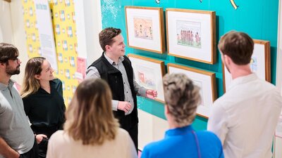 tour guide with tour group looking at cartoon images on a wall