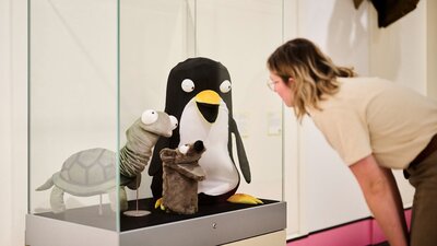 lady looking at cartoon animals on display in glass cabinet