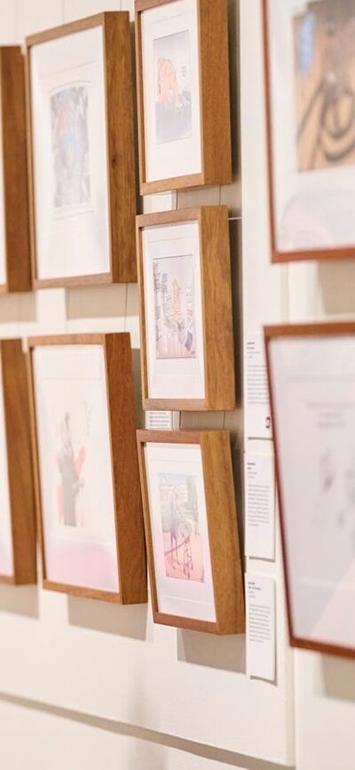 lady wearing headphones looking at photos on a wall