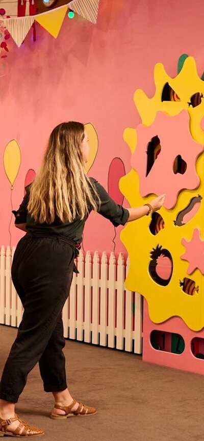 people looking at colourful wall display at Behind the lines exhibition