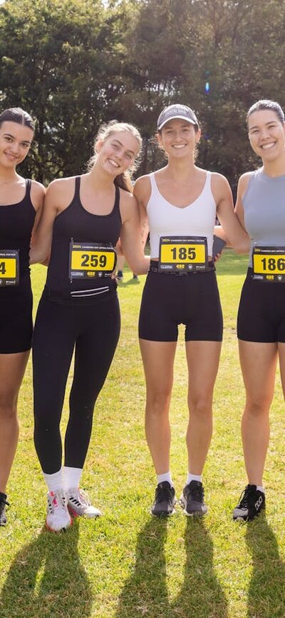 Group of people smiling to the camera, prior to participating in the fun run