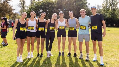 Group of people smiling to the camera, prior to participating in the fun run