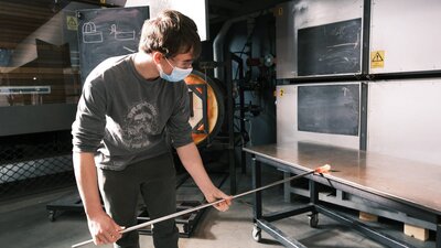 Teen blowing glass in the Hotshop