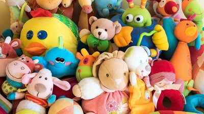 a variety of soft plush toys on display at a market