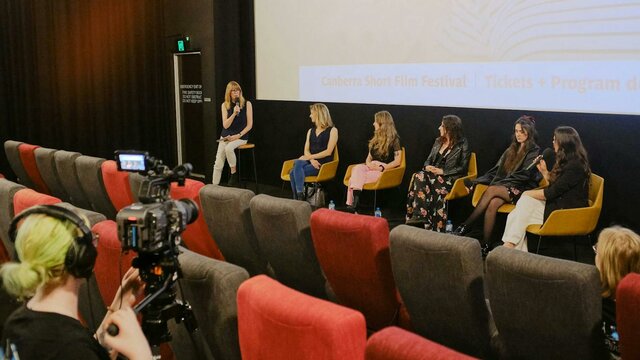 Panel at a previous CSFF screening The image depicts a panel discussion taking place in front of a cinema screen
