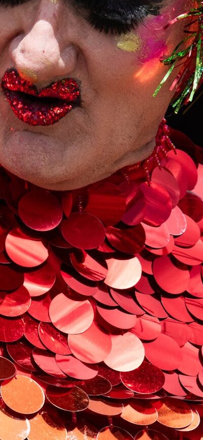 Drag Performer in brightly coloured costume and headress performing at Fair Day