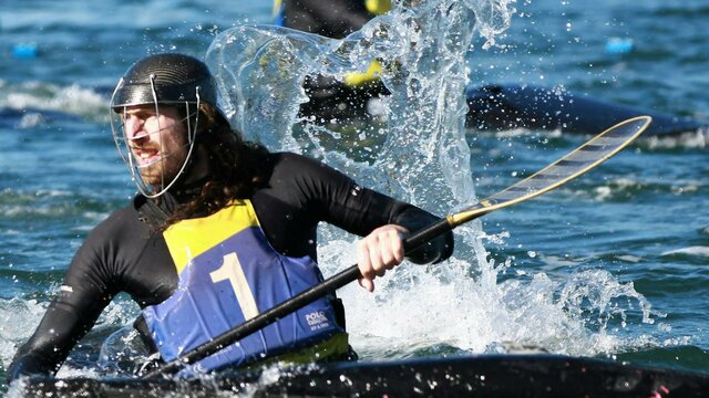 A single player is in the foreground, he is looking back whilst water splashes around him