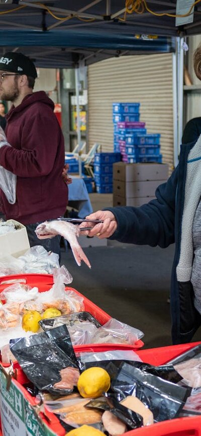 shoppers selecting fresh seafood from local farmers market in Canberra