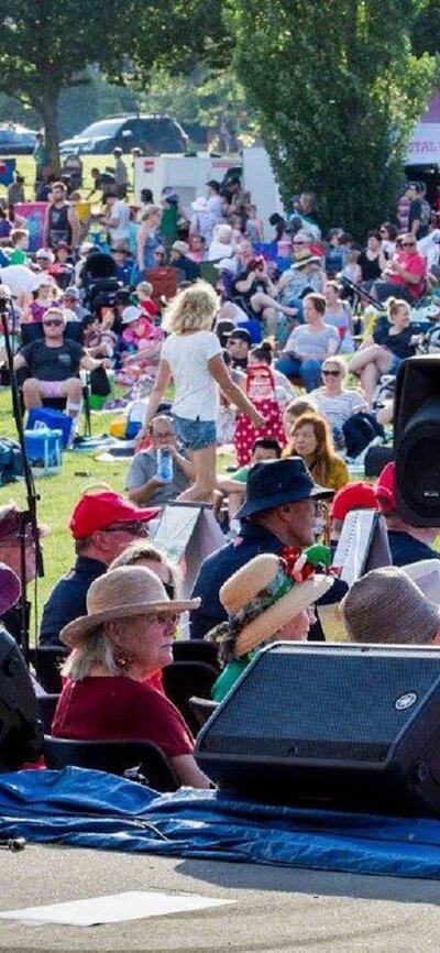 performer on stage with audience inb background at Carols in Town Park Canberra