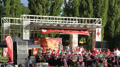 Carollers performing on stage at Carols in Town Park Canberra