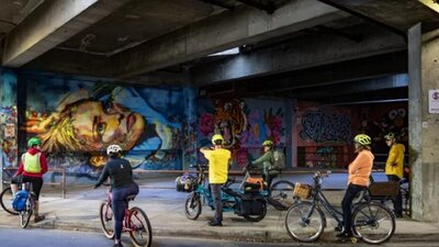 Group of cyclists looking at graffiti wall