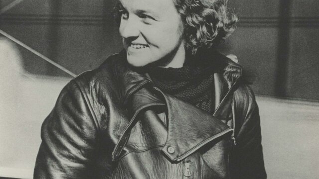 nla.gov.au/nla.obj-3923190274 A sepia photograph of a woman with curly hair in flight gear.