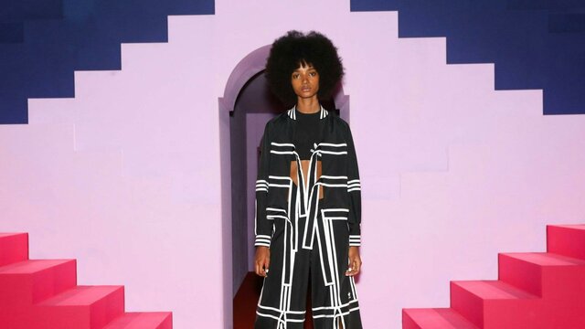 Ji Won Choi x Adidas. Courtesy Adidas Lady modelling outfit behind pink stairs and purple background