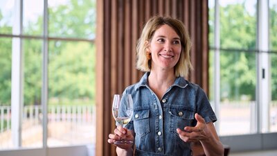 Emma Shaw of the Canberra Cellar Door A woman holding a glass of wine, gesturing