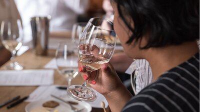 A young woman sniffs a glass of wine