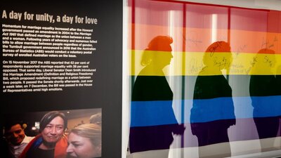 Rainbow flag in exhibition display next to photo of Senator Penny Wong