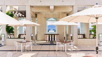 Chairs and tables with sun umbrellas on a terrace on a sunny day.