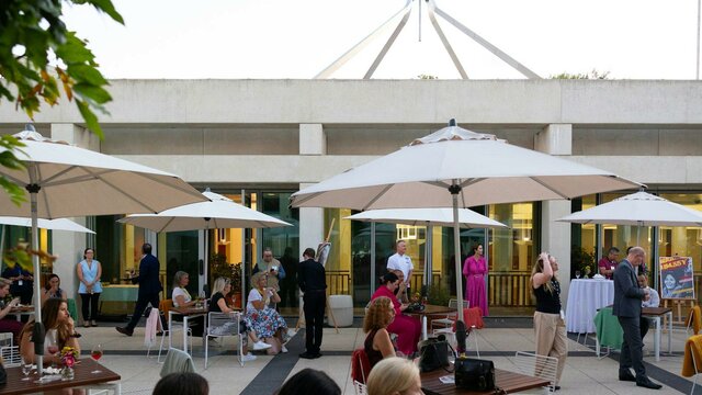 The Queen's Terrace at dusk filled with people.