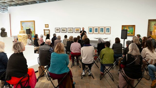 Art Talk. Photograph by Sam Cooper. Photo of a group of people sitting in a gallery listening to someone talk