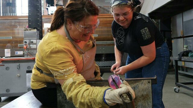 Make Your Own glassblowing class at Canberra Glassworks teacher and participant blowing glass in the Hotshop