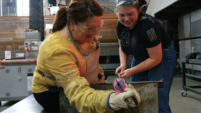 Make Your Own glassblowing class at Canberra Glassworks teacher and participant blowing glass in the Hotshop