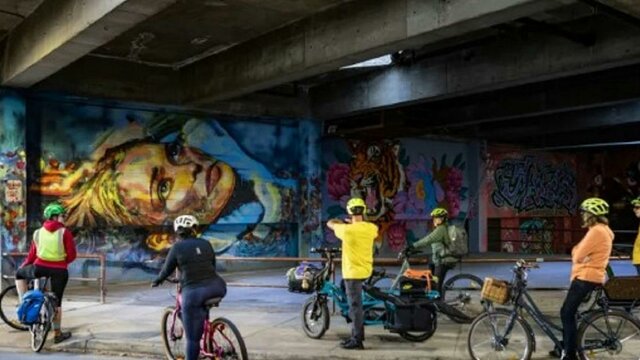 Group of cyclists looking at graffiti wall