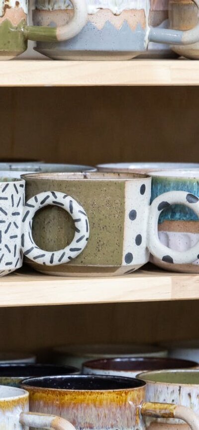 Public Holiday Ceramics Colourful ceramic mugs sitting on shelves