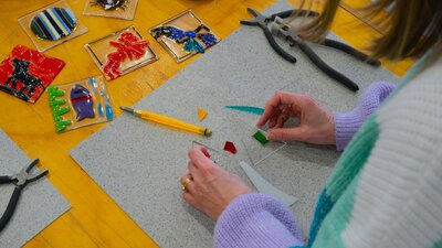 Participant arranging glass tiles to make a Christmas ornament