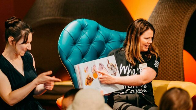 Photo of a Museum staff member and an Auslan interpreter signing a book in the Discovery Centre
