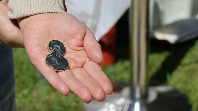 Holding some newly traded coins at the Mint a hand holding 2 traded coins at the Mint