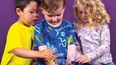 Three young children doing a science experiment