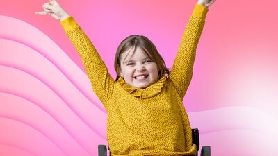 Young child smiling with arms raised in the air