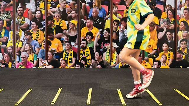 Matildas: Make and Move at the National Portrait Gallery A child wearing a Matildas jersey jumps on an indoor soccer footwork activity.