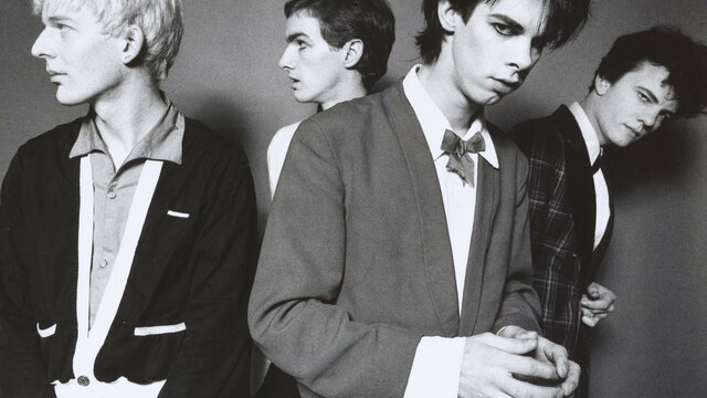 The Boys Next Door, 1978 Michel Lawrence. © Michel Lawrence A monochrome photographic portrait of four men with candid expressions wearing suits.