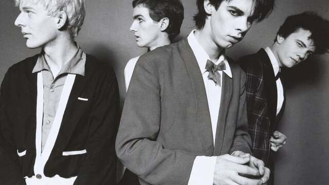 The Boys Next Door, 1978 Michel Lawrence. © Michel Lawrence A monochrome photographic portrait of four men with candid expressions wearing suits.