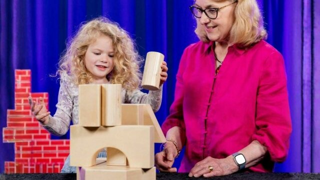 A child and her grandmother playing with blocks at Science Time Female child playing with building blocks next to her grandmother