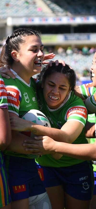 The Raiders NRLW team celebrate a try against the Knights
