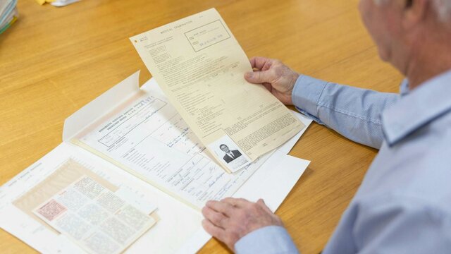 Photpgraph of a visitor reading archival records at a table