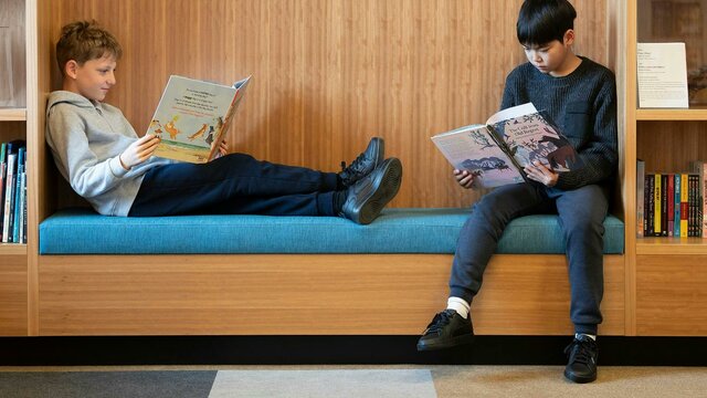 School holiday activity: The love of storytelling. National Library of Australia. Two kids sitting down and reading NLA Publishing picture books.